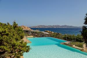a swimming pool with a view of the water at Hotel Cala Lunga in La Maddalena