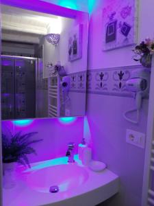 różowa łazienka z umywalką i lustrem w obiekcie Le Ninfe del Mare w mieście Polignano a Mare