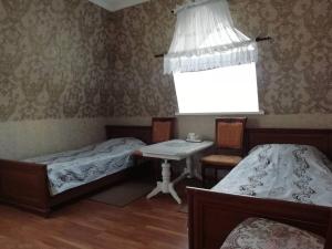 a room with two beds and a table and a window at Отель Буржуа in Zhytomyr
