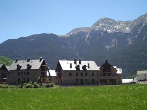 a building in a field with mountains in the background at Apartamento Millas in San Juan de Plan +3 photos
