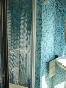 bagno piastrellato blu con doccia e lavandino di Appunti di Viaggio Room & Breakfast a San Giorgio di Piano