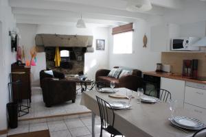 a kitchen and living room with a table and chairs at Gîtes Le Bout du Monde in Le Conquet