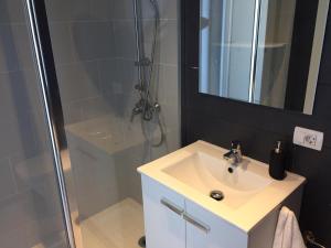 a bathroom with a sink and a shower with a mirror at Sea loft with a huge bed in Icod de los Vinos +23 photos