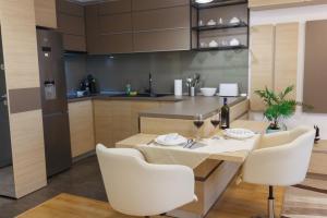 a kitchen with a table with white chairs and a dining room at Presecan One Room Apartment with view in Cluj-Napoca