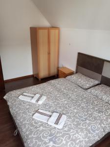 a bedroom with a bed with two towels on it at Apartment and rooms D&J in Žabljak
