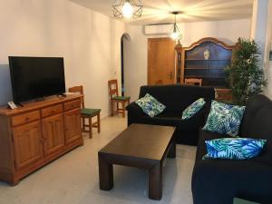 sala de estar con TV en un centro de entretenimiento de madera en Playa San Miguel, en Cartaya