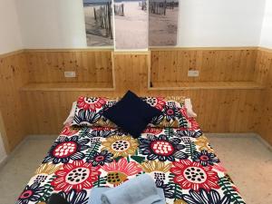 1 dormitorio con 1 cama con una manta colorida en Playa San Miguel, en Cartaya