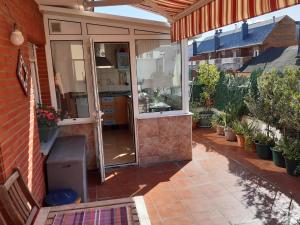 an outdoor kitchen with glass doors on a house at Ático con terraza céntrico Oviedo in Oviedo
