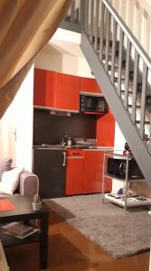uma cozinha com armários laranja e uma escadaria em Ubaye Liberty em Barcelonnette