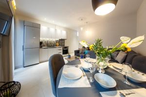 a dining room with a table and a kitchen at San Marco Elegant Apartment Zante in Zakynthos
