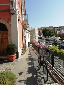 Una bicicleta estacionada al lado de una valla en una calle en Melfi, città delle Costituzioni di Federico II - Casa vacanze, en Melfi