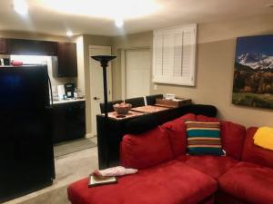 Denver Blue Bear Den 3BR 2BA & Spa في دنفر: غرفة معيشة مع أريكة حمراء ومطبخ