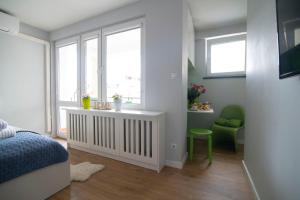 - une chambre avec un lit, une fenêtre et une chaise dans l'établissement WLR Apartments - Hoza II, à Varsovie
