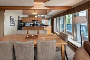 a kitchen and dining room with a wooden table and chairs at Village Gate House by Whiski Jack in Whistler