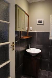 a bathroom with a sink and a mirror at The Cottage 60 on 21st Avenue in Mossel Bay
