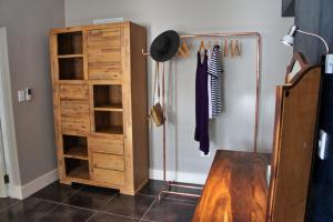 a closet with a wooden cabinet next to a refrigerator at The Cottage 60 on 21st Avenue in Mossel Bay