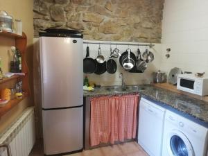 a kitchen with a refrigerator and a sink at Casa Rural Can Met in Llorá
