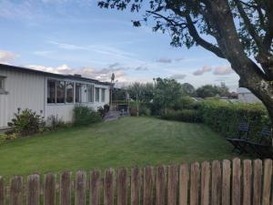 a yard with a fence and a house at Family room in Trönninge