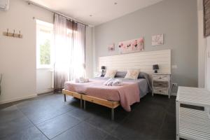 Un dormitorio con una cama con una manta rosa. en Le Cupole, en Roma 14 fotos más