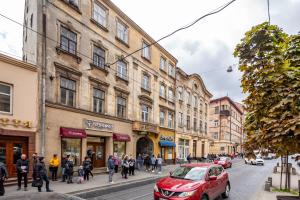 a group of people walking down a street with buildings at Apartment with 2 bedroom near Opera House Gorodotska 27 str with parking in Lviv