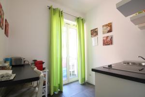 una cocina con cortinas verdes y fregadero en Le Cupole, en Roma