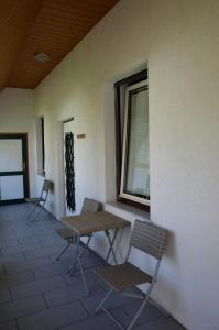 3 Stühle, ein Tisch und ein Fenster auf einem Gebäude in der Unterkunft Zimmervermietung Fasching in Sankt Pölten