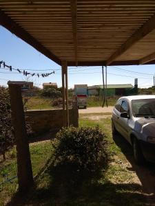 a car parked under a shed with a fence and a car at Cabaña Gabon in Barra del Chuy