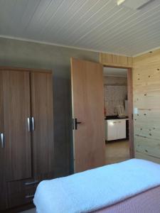 1 dormitorio con 1 cama y armarios de madera en Itsasoa, en Barra del Chuy