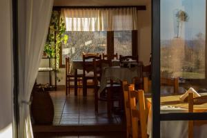 a dining room with a table and chairs and a window at Los Abedules Cabañas in Villa Alpina