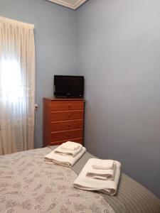 a bedroom with a bed with two towels on it at Apartamento La Villa in Portugalete