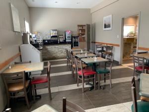 a restaurant with tables and chairs in a room at Sword Inn Bancroft in Bancroft