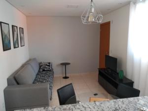 uma sala de estar com um sofá e uma televisão em Residencial em Belo Horizonte