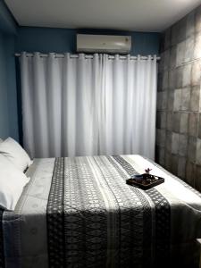 Una cama con una bandeja en un dormitorio en Mello's House, en Curitiba