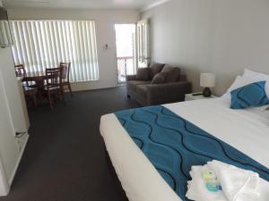 a hotel room with a bed, chair, and table at Sussex Shores in Sussex inlet