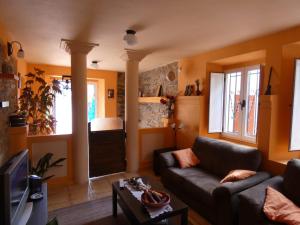 ein Wohnzimmer mit einem Sofa und einem TV in der Unterkunft Casa de Corbelle in Muimenta