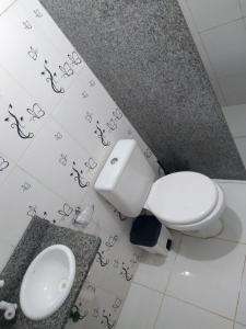 ein Badezimmer mit weißer Toilette und Waschbecken in der Unterkunft Bosque dos Esquilos in Abraão