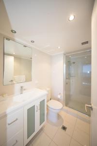 a bathroom with a toilet and a sink and a shower at Beachside Tower Apartments in Gold Coast