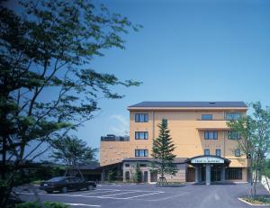 un edificio con un'auto parcheggiata in un parcheggio di Hotel Io Alpheratz a Kasama
