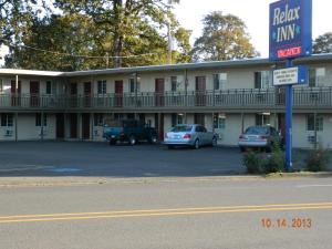 um hotel com carros estacionados num parque de estacionamento em Relax Inn - Cottage Grove em Cottage Grove