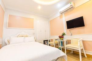um quarto com uma cama e uma televisão de ecrã plano em An loc hotel em Dien Bien Phu