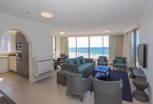 a living room with a blue couch and chairs at Beachside Tower Apartments in Gold Coast