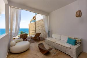 Sala de estar con sofá blanco y vistas al océano en Dco Suites Lounge & Spa en Máncora