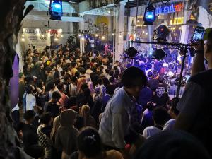 a crowd of people in a room with lights at Bat & Arrow in Padang