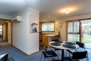 a kitchen and dining room with a table and chairs at Acton Park Holiday Units in Acton Park