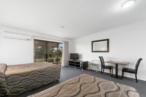 a bedroom with a bed and a desk and a table at Comfort Inn & Suites Riverland in Barmera