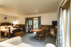 a hotel room with a bed and a table and chairs at Cradle forest inn in Moina