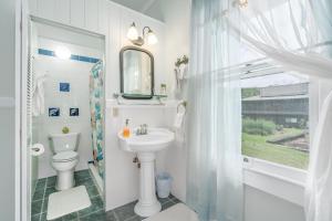 ein Badezimmer mit einem Waschbecken, einem WC und einem Spiegel in der Unterkunft Old Hawaiian Bed and Breakfast in Hilo