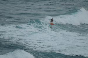 una persona montando una ola en una tabla de surf en el océano en Mizata By Antiresort, en Santa María Mizata