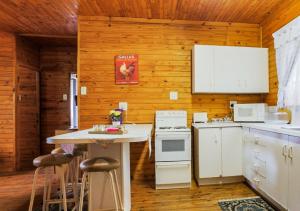 une cuisine avec des appareils électroménagers blancs et une table avec des tabourets dans l'établissement Viewpoint Lodge & Safari Tours, à Hazyview