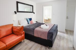 a bedroom with a bed and a couch at Brunker Suites in Newcastle